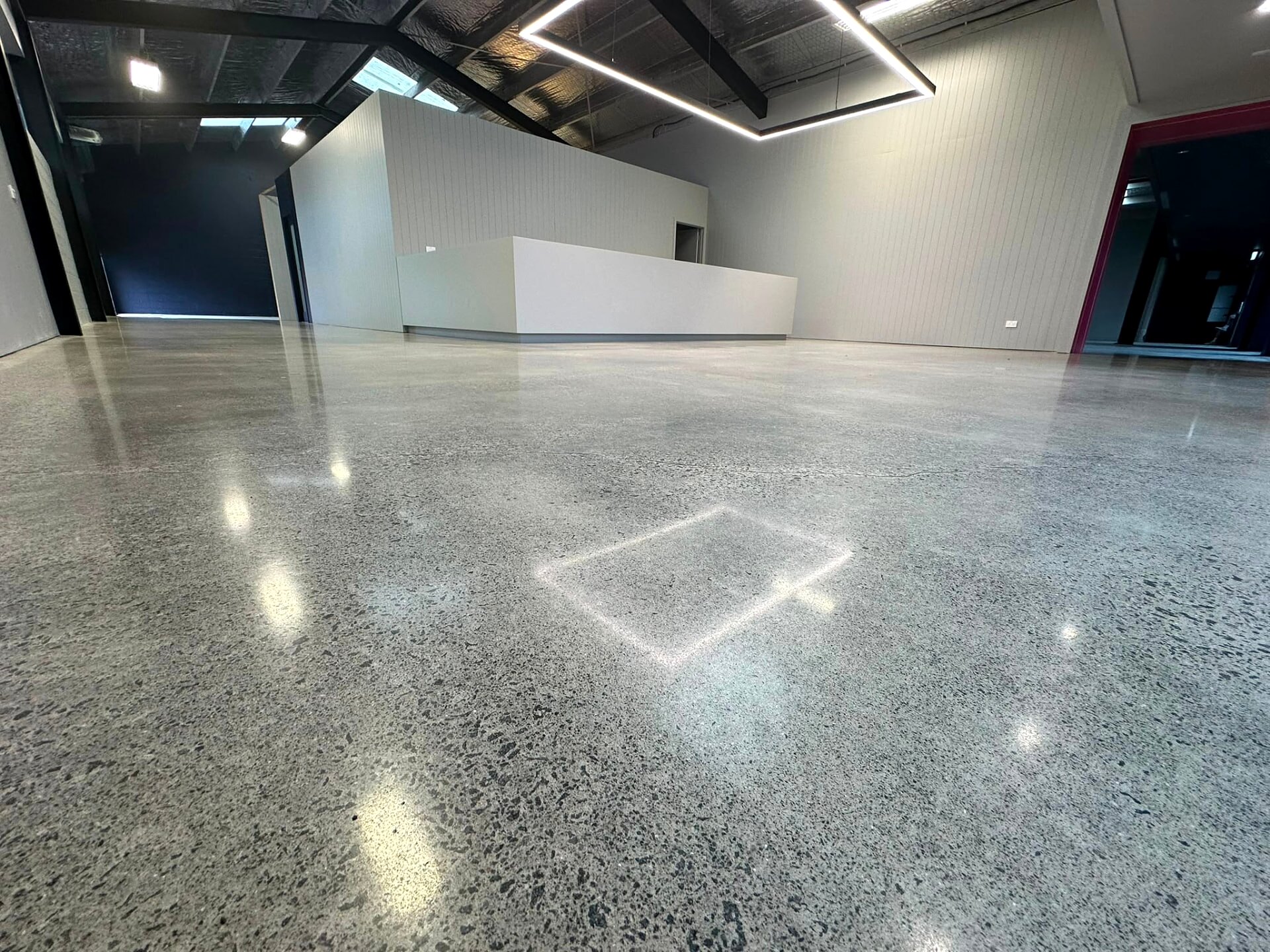Polished concrete floor running the length of a bare commercial interior